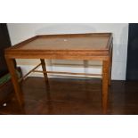 A mid 20th century golden oak bed/occasional table having fixed tray top