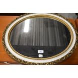 A vintage oval wall mirror, gilt plaster with white trim, width approx 56cm max.