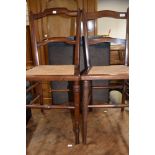 A pair of Edwardian mahogany bedroom chairs having canework seats and turned legs