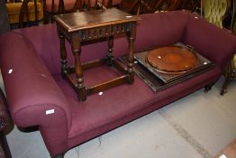 A traditional chesterfield settee having re-upholstery on turned legs