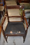 An early 19th century Regency design dining armchair having slat back and turned legs