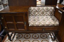 A 1970's design oak telephone table having integral seat