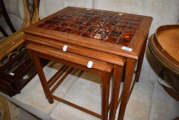 A vintage teak and tile top nest of three tables