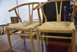 A pair of 1970's rubber wood Scandi inspired kitchen chairs, having bentwood arms and canework