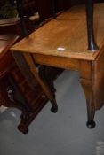 An early 20th century oval drop leaf gate leg dining table on pad feet