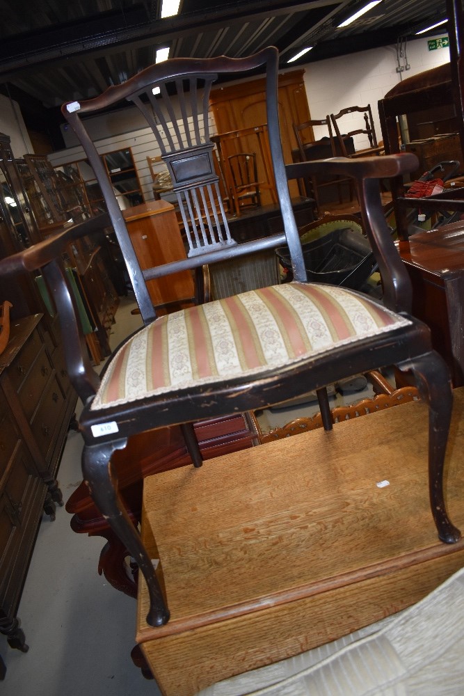 An Edwardian mahogany salon armchair having shaped slat back having striped upholstery and pad feet