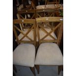 A set of four modern dining chairs having upholstered seats