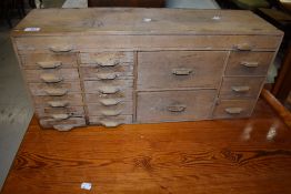A small stripped set of counter top merchants or specimen drawers