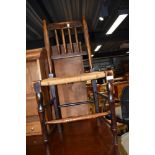 An early 19th century elm spindle back vernacular chair having rush seat