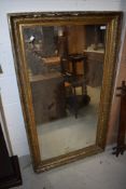 An early 20th Century gilt frame wall mirror, some distressing, approx 132 x 75cm