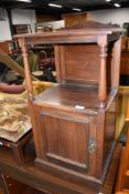 An early 20th century mahogany pot cupboard having shelf top with turned supports and cupboard