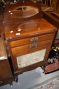 A late Victorian mahogany music cabinet having scroll mirror back, over drawers and mirror door on