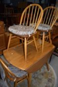 A light beech Ercol drop leaf dining tabe and set of four hoop and stick back dining chairs