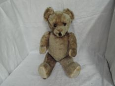 A mid 20th century straw filled yellow plush Teddy Bear having plastic eyes, stitched nose and