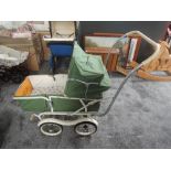 A 1960's TanSad Dolls Pram genuine model 322 having green canopy hood with cream interior on twin