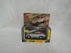 A Corgi diecast, James Bond Aston Martin with driver and two bandits, on inner card display stand