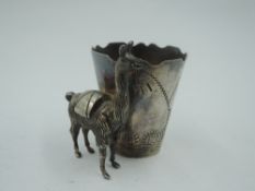 A small white metal tot 'glass' stamped 925 Peru having engraved scenic decoration and Llama model