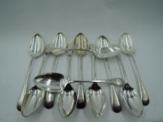 Eleven Edwardian silver dessert spoons of plain Old English form bearing initial J to terminals,