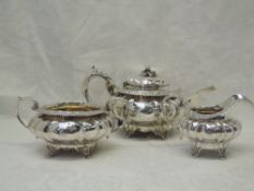 A Georgian silver three piece matched tea set of facetted form having floral knop, bracket feet, and