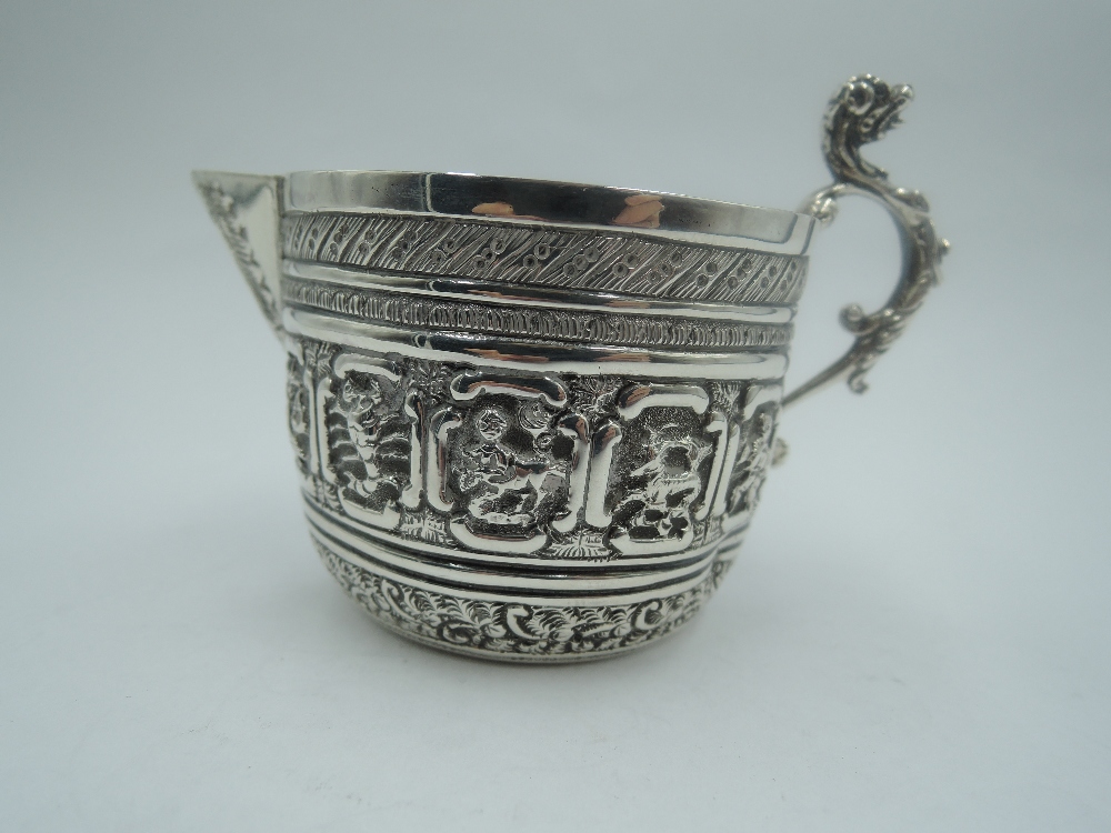 A Victorian silver cream jug having zodiac panel decoration, plain cartouche and cast dog mask