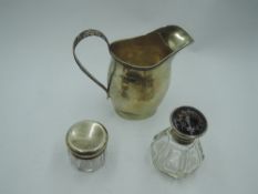 A small silver cream jug of helmet form having acanthus leaf loop handle, Chester 1911, George