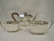 A 1930's three piece silver tea set in the Art Deco style having fruit wood handle and decorative