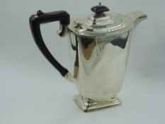 A silver hot water pot of plain tapered oval form to square pedestal base with fruitwood handle &