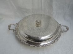 A large silver lidded serving tureen of heavy circular form having engraved decoration with