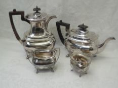 A four piece silver tea set of ovoid form having paw feet, soft wood handles, bear arm crest to