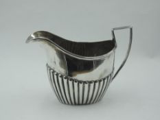 A Victorian silver cream jug having gadrooned decoration, Chester 1899, makers marks worn, approx