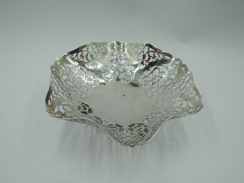 A 1930's silver trinket dish having shaped and pierced decoration and trefoil bun feet, Birmingham