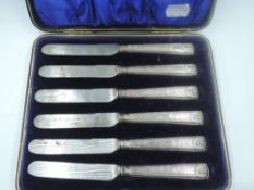 A cased set of six Edwardian silver handled dessert knives having moulded handles with scallop shell