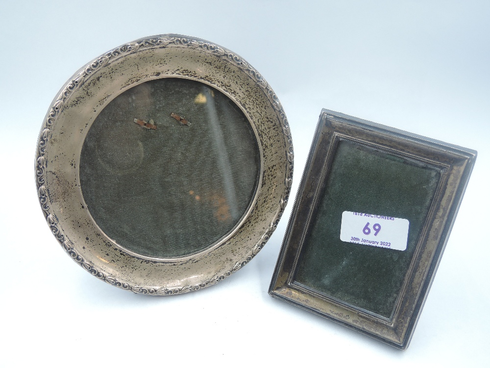 An HM silver photograph frame of circular form having moulded rim and green leather easel stand,