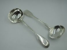 A pair of Victorian silver sauce ladles in the fiddle and thread pattern, bearing (worn) monogram to