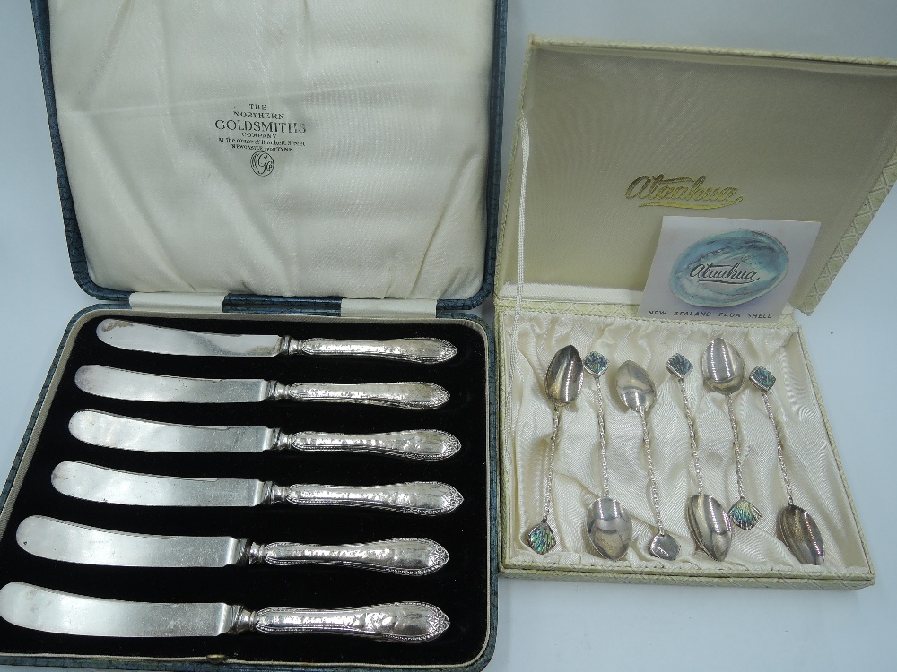 A cased set of HM silver handled butter knives and a cased set of New Zealand white metal coffee