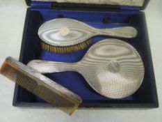 A cased three piece silver dressing table set having engine turned decoration and inscribed 'edith',