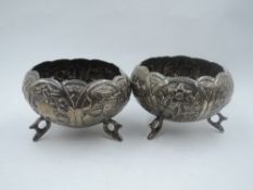 A pair of continental white metal footed bowls having repousse scenic and floral panels, plain