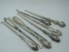 Eight HM silver handled button hooks of various forms