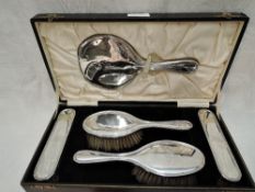 A cased silver 5 piece dressing table set of plain form bearing monogram to backs (missing comb),