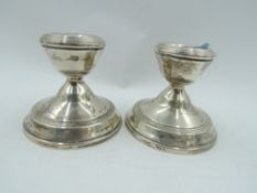 A pair of silver candle sticks of squat form with weighted bases, Birmingham 1968, W I Broadway