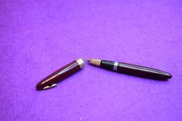 A Sheaffer Statesman Tuckaway plunger fill fountain pen in red with broad band to lip of cap