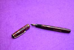 A Burnham No49 leverfill fountain pen in red marble with single narrow band to the cap having