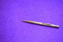 A Fyne Poynt propelling pencil in gold with engine turned decoration