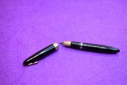 A Sheaffer Lifetime Tuckaway fountain pen with plunger fill in black with broad band to cap having a
