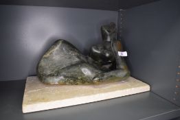 A modernist style stone sculpture in a Henry Moore design of a reclining nude woman approx 50cm