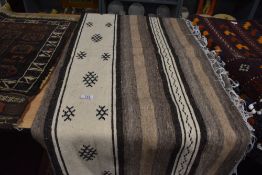 A hand woven light cream woolen blanket or throw