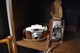 Two vintage cameras including Kodak and Eumig.