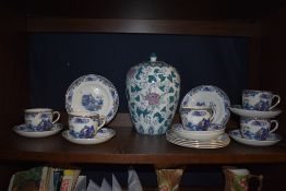 A selection of oriental style cups and saucers and a large jar.