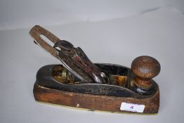 A woodworkers or cabinet makers smoothing plane with brass plate metal case and wooden body by