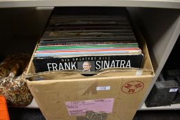 A box of mixed vinyl LP records.